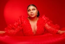 Elegant portrait of a woman posing in a bold red satin dress with dramatic lighting.