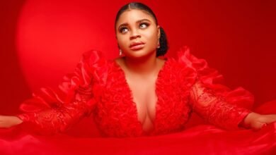 Elegant portrait of a woman posing in a bold red satin dress with dramatic lighting.